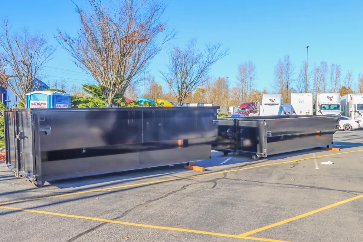 Professional dumpster rental service with roll-off container on residential driveway in Harrisonville